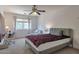 Bright bedroom with plush carpet, ceiling fan, large window with natural light, and a comfortable seating area at 8534 W Salter Dr, Peoria, AZ 85382