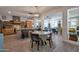 Open-concept kitchen and living space with island seating, modern light fixtures, and beautiful wood flooring at 8534 W Salter Dr, Peoria, AZ 85382