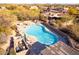 Aerial view of outdoor pool with desert landscaping and nearby covered patio at 9200 E Whitethorn Cir # 601, Scottsdale, AZ 85266