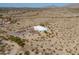 Aerial view of a secluded modern home nestled in a vast desert landscape with mountain views, showcasing its privacy at 10020 W Tortalita Way, Casa Grande, AZ 85194