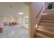 Spacious finished basement featuring neutral tile flooring, a staircase, and an adjacent dining area with seating at 10020 W Tortalita Way, Casa Grande, AZ 85194