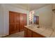 Bathroom with tiled counter, sink, wooden cabinets, large mirror, and closet at 10020 W Tortalita Way, Casa Grande, AZ 85194