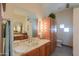 Bright bathroom featuring a vanity with dual sinks, tile countertops, and ample storage at 10020 W Tortalita Way, Casa Grande, AZ 85194
