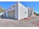 Modern home exterior showcasing the clean lines, a two-car garage, and xeriscaping, complemented by desert landscape at 10020 W Tortalita Way, Casa Grande, AZ 85194