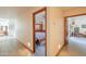 Bright hallway featuring tile flooring and views into the bedroom and living spaces with beautiful door casings at 10020 W Tortalita Way, Casa Grande, AZ 85194