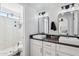 Bright bathroom featuring double sinks, dark counters and an enclosed shower with gray marble style tile at 1025 E Highland Ave # 6, Phoenix, AZ 85014