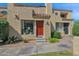 Inviting townhome featuring a warm red door, manicured landscaping, and cozy, sunlit windows at 1025 E Highland Ave # 6, Phoenix, AZ 85014