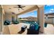 Covered patio with comfortable seating overlooks a beautiful pool and backyard at 10335 E Catalyst Ave, Mesa, AZ 85212