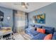 Comfortable bedroom featuring a blue sofa, desk, and soft natural light through window at 10426 N 10Th St # 1, Phoenix, AZ 85020