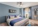 Inviting bedroom with a ceiling fan, a large bed with blue accents, and natural light from the window at 10426 N 10Th St # 1, Phoenix, AZ 85020