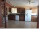 A kitchen featuring tile floors, white appliances, wood cabinets, and a window at 1113 E Bisnaga St, Casa Grande, AZ 85122