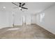 Open-concept living space with tile floors, ceiling fan, and neutral color palette at 11718 W Port Au Prince Ln, El Mirage, AZ 85335