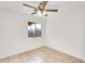 Bright bedroom with a ceiling fan, window and neutral tile flooring at 11825 W Flanagan St, Avondale, AZ 85323