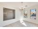 Well-lit dining area with tile flooring, a modern chandelier, and expansive windows for ample natural light at 11825 W Flanagan St, Avondale, AZ 85323