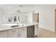 Modern kitchen with white cabinets, stainless appliances, and breakfast bar overlooking the living space at 11825 W Flanagan St, Avondale, AZ 85323