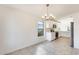 A well-lit kitchen featuring white cabinetry, modern appliances, and a stylish chandelier in the adjacent dining space at 11825 W Flanagan St, Avondale, AZ 85323