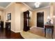 Elegant entryway with hardwood and tile flooring, complemented by a decorative table and grandfather clock at 13655 W Junipero Dr, Sun City West, AZ 85375