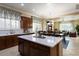 Spacious kitchen island with white countertops and dark wood cabinets, with view to dining and living areas at 13655 W Junipero Dr, Sun City West, AZ 85375