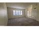 Cozy living room featuring neutral walls, carpet, and plantation shutters providing natural light and privacy at 13911 W Gable Hill Dr, Sun City West, AZ 85375