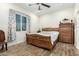 Comfortable bedroom with a ceiling fan, tile floor, view, and a wooden dresser at 1415 N 357Th Ave, Tonopah, AZ 85354