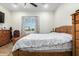 Comfortable bedroom with a ceiling fan, tile floor, view, and a wooden dresser at 1415 N 357Th Ave, Tonopah, AZ 85354