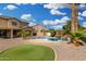 Large backyard with a pool, waterfall feature, artificial turf, and gravel at 15357 W Post Cir, Surprise, AZ 85374