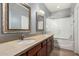 Bathroom with a double sink vanity, framed mirrors, and a shower over tub providing elegance and functionality at 15357 W Post Cir, Surprise, AZ 85374