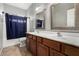 Bathroom featuring dual sinks and a shower with a blue curtain at 15357 W Post Cir, Surprise, AZ 85374