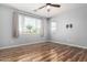 A spacious bedroom features laminate floors, large windows, and a ceiling fan at 15357 W Post Cir, Surprise, AZ 85374