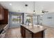 A kitchen island with sink and dining area boasts generous counter space and tiled flooring at 15357 W Post Cir, Surprise, AZ 85374