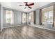 Sunlit living room with wood-look floors, curtains, and multiple windows for ample light at 15357 W Post Cir, Surprise, AZ 85374