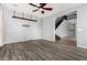 Open living room showcasing wood-look floors, ceiling fan, and staircase access at 15357 W Post Cir, Surprise, AZ 85374