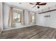 Bright living room featuring wood-look floors, ceiling fan, and windows with natural light at 15357 W Post Cir, Surprise, AZ 85374