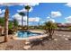 Inviting pool with rock features, tall palms, stepping stones and low maintenance yard at 15357 W Post Cir, Surprise, AZ 85374