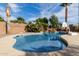 Backyard pool and waterfall with lush, tropical landscaping and basketball hoop at 15357 W Post Cir, Surprise, AZ 85374
