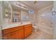 Bright bathroom showcasing a wood vanity with a light countertop, tile flooring and shower with bathtub at 1612 E South Mountain Ave, Phoenix, AZ 85042