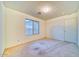 A carpeted bedroom with a window allowing natural light and a closet with standard door at 1612 E South Mountain Ave, Phoenix, AZ 85042