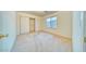 A bright bedroom features a large window, closet with sliding doors, and neutral carpet flooring at 1612 E South Mountain Ave, Phoenix, AZ 85042