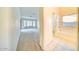 Hallway view leading to a bathroom and room featuring carpet and natural lighting at 1612 E South Mountain Ave, Phoenix, AZ 85042