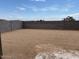 A spacious and flat backyard bordered by a block wall under a partly cloudy sky at 17449 W Eva St, Waddell, AZ 85355