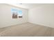 Bright bedroom featuring a large window and neutral carpet at 17449 W Eva St, Waddell, AZ 85355