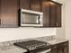 Close-up of the stainless steel microwave, gas cooktop, and granite countertops at 17449 W Eva St, Waddell, AZ 85355