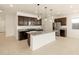 Modern kitchen featuring dark wood cabinetry, granite countertops, and stainless steel appliances at 17449 W Eva St, Waddell, AZ 85355
