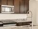 Close-up of the stainless steel microwave, gas cooktop, and granite countertops at 17449 W Eva St, Waddell, AZ 85355