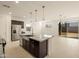 Open-concept kitchen with stainless steel appliances, granite countertops, and a spacious island at 17449 W Eva St, Waddell, AZ 85355