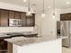 Stylish kitchen with stainless steel appliances, dark wood cabinets, and a granite island at 17449 W Eva St, Waddell, AZ 85355