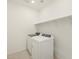 Bright laundry room featuring a modern washer and dryer and a shelf for storage at 17449 W Eva St, Waddell, AZ 85355