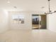 Bright living room featuring tile floors and a sliding glass door leading to the backyard at 17449 W Eva St, Waddell, AZ 85355