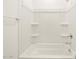 Bright white tub and shower combination with built in shelves at 17449 W Eva St, Waddell, AZ 85355