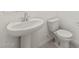 This half bathroom features a pedestal sink, toilet and neutral colors at 17624 W Pierson St, Goodyear, AZ 85395